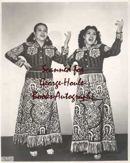 Two women in long shirts, singing.